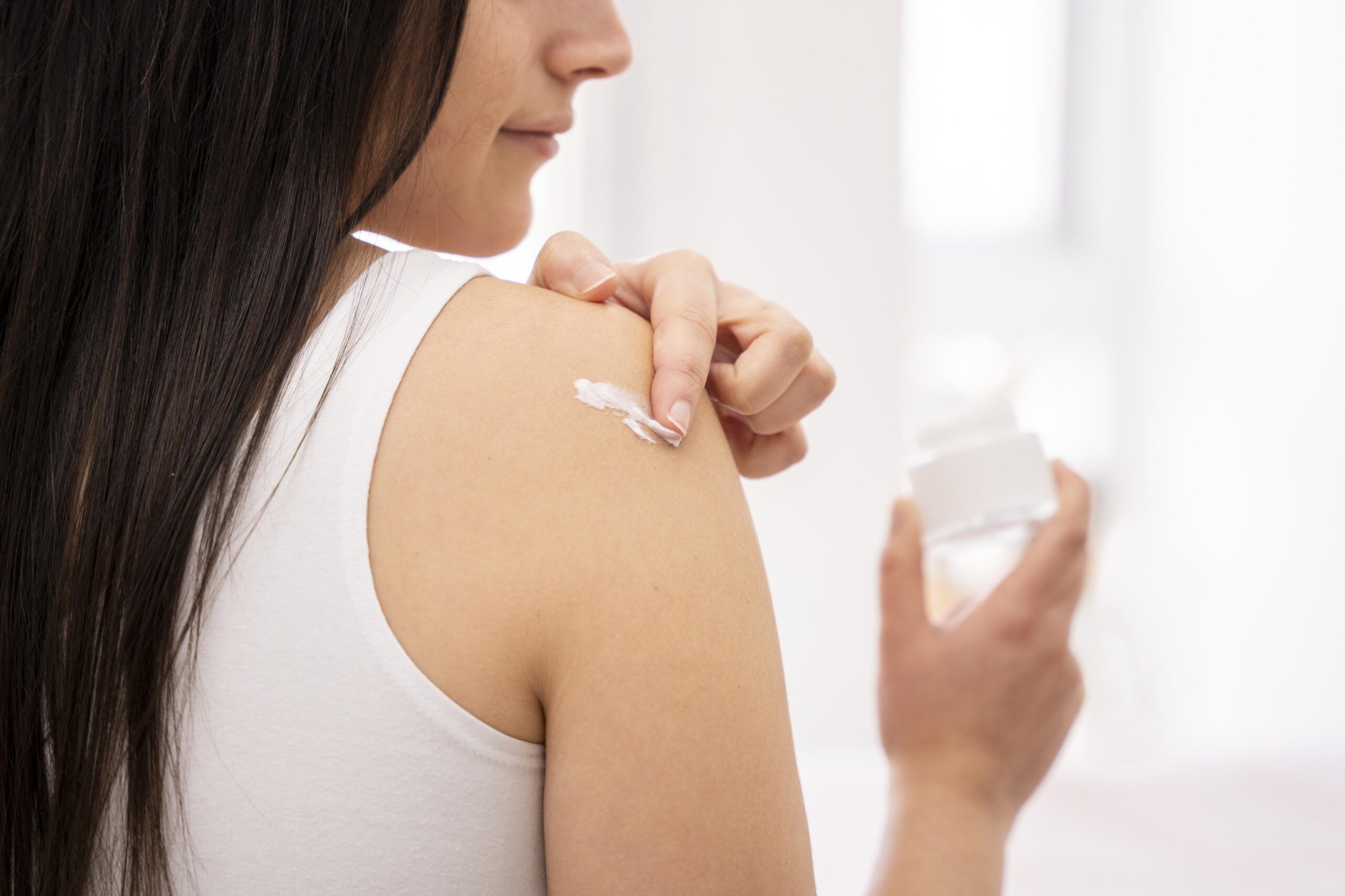 close-up-woman-applying-cream-shoulder